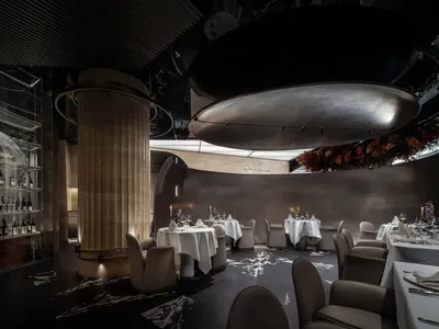 Interior design of a modern restaurant featuring metal, stone, and glass materials.