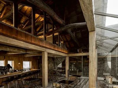 An industrial-style restaurant interior with exposed wooden beams and rustic furniture.