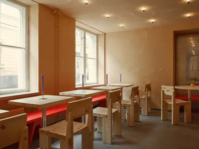Restaurant with industrial-style wooden furniture and red benches