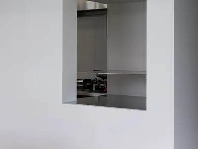 A modern kitchen interior with metallic wall panels and stainless steel countertops.