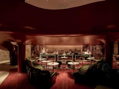 Modern restaurant and bar interior with metallic walls and tables.