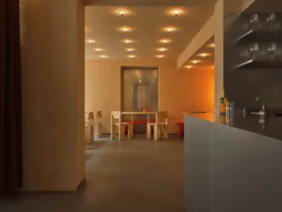 A modern restaurant interior with concrete and wooden materials.