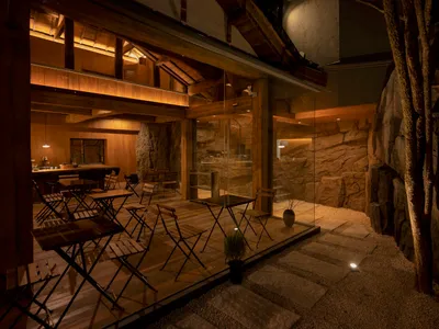 木石主題的餐廳酒店衛浴，露出木樑與岩石紋理牆面