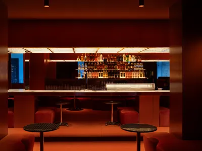 Industrial-style restaurant bar with metallic tables and barstools