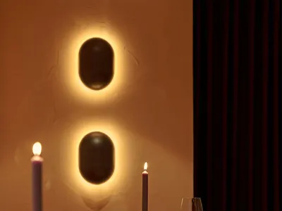 A minimalist restaurant with candlelit tables and wooden chairs, featuring warm lighting and a cozy atmosphere.