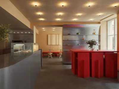 Modern restaurant interior featuring metallic surfaces and wooden elements.