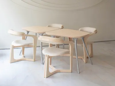 A photograph of a modern restaurant interior featuring wooden tables and chairs with a circular textured wall and ceiling des