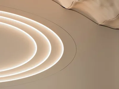 Modern restaurant interior with round wooden table, chairs, and illuminated architectural design on the ceiling.