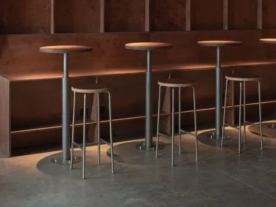 High-top bar tables and stools in a wooden restaurant interior with exposed ceiling beams
