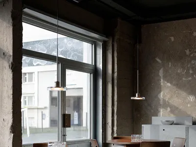 Industrial-style restaurant interior with concrete walls and timber furniture.