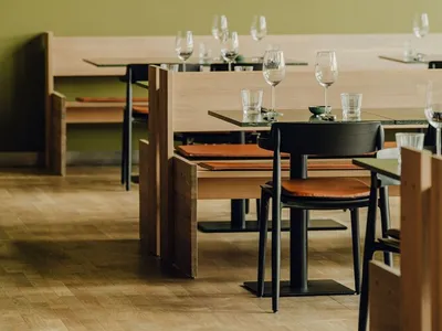 Modern restaurant interior with metallic lights and wooden tables and chairs.