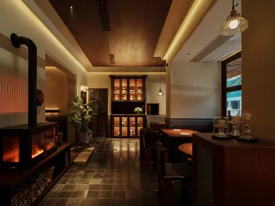 Modern restaurant bar featuring wooden accents, marble countertops, and glass cabinets.