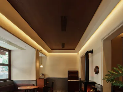 A modern restaurant interior featuring wood-paneled walls and tiled flooring.