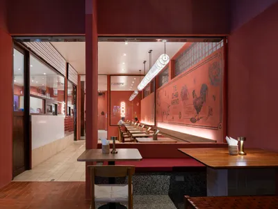 Modern restaurant interior featuring wooden furniture and concrete floor