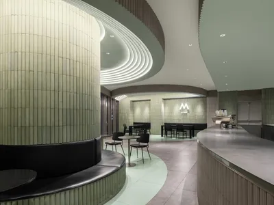 A modern restaurant interior with green tiles and concrete accents