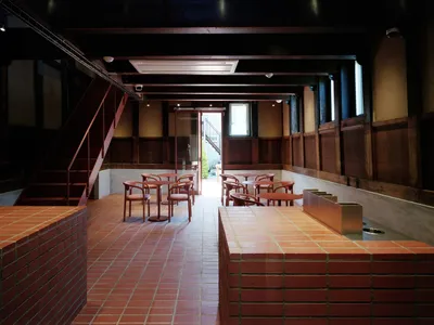 Modern cafe interior with brick walls, concrete flooring, and wooden furniture.