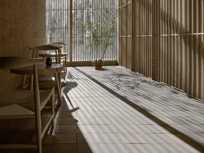 A modern restaurant interior with clear glass walls and wooden elements.