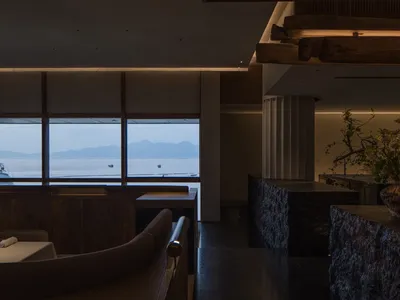 現代餐廳室內，木質座位區搭配大型窗戶，眺望山景。