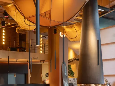 An industrial-style restaurant featuring metal, wood, and glass elements.