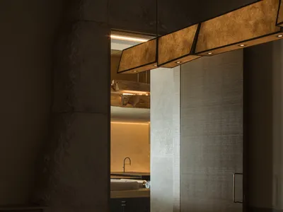 Modern restaurant interior with wooden floors and concrete walls, featuring a dining table set for a meal.