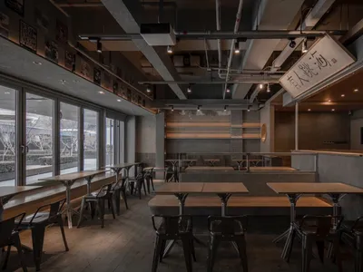 Industrial-style restaurant interior with concrete, wood, and metal elements.
