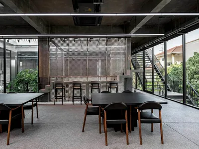 An industrial-style restaurant with metal, concrete, and glass elements.