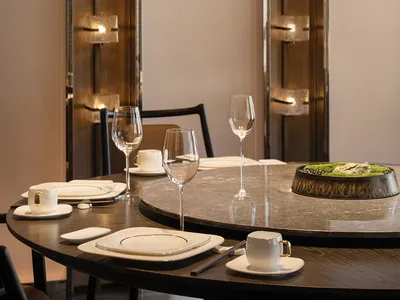 A modern restaurant table setting with marble table and glassware.