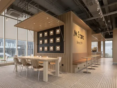 Modern, industrial-style restaurant interior with a long dining table and chairs.