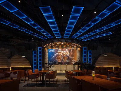 A modern industrial-themed restaurant with mixed materials and blue lighting.