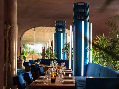 A modern restaurant interior featuring blue textiles and wooden elements.