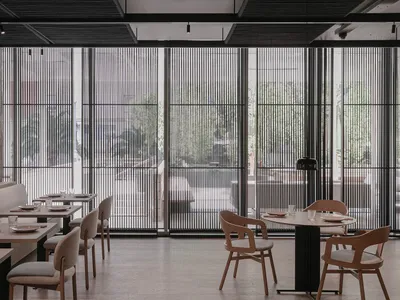 Modern restaurant interior with concrete and wooden elements, featuring contemporary design and comfortable seating arrangeme