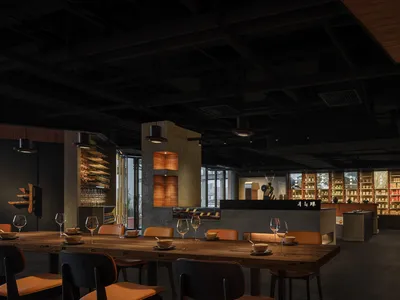 Modern, industrial restaurant interior with concrete walls and wood accents, featuring a long communal table and a monochroma