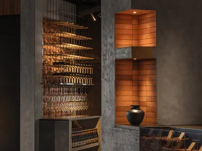 Industrial design restaurant interior with concrete shelves and illuminated brick wall feature.