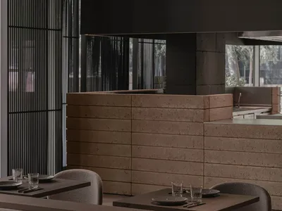 Modern restaurant interior with concrete counter and seating area.