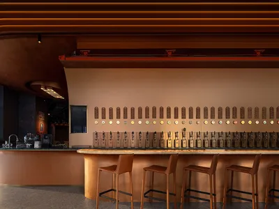A modern bar interior with porcelain walls and metal bar