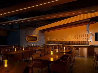 A modern restaurant bar with warm lighting and Walnut wood finish