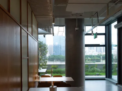 A modern restaurant cafe interior featuring concrete and wooden elements.