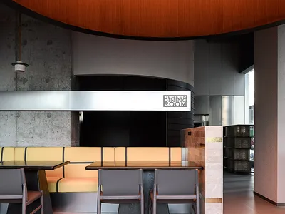 Modern interior design of a restaurant dining room featuring wooden elements and curved architecture.