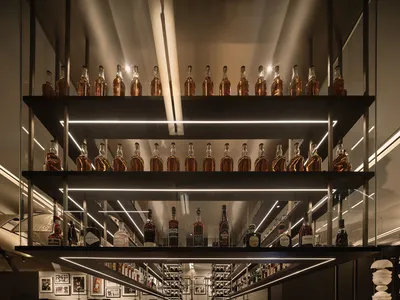 A well-lit, modern restaurant bar with electronic shelves displaying bottles.