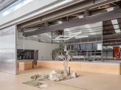 Concrete and industrial materials dominate the interior design of a restaurant.