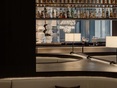 Industrial design restaurant interior with metal shelves, glass bottles, and marble tables.
