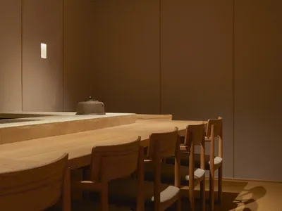 A minimalist restaurant bar featuring natural wood elements and soft lighting.