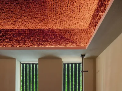 Modern hotel lounge with textured ceiling and concrete flooring.