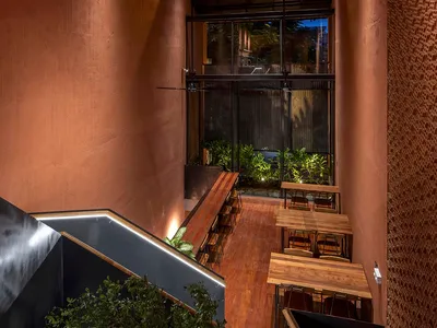 Indoor restaurant space with exposed metal roof and industrial design elements.