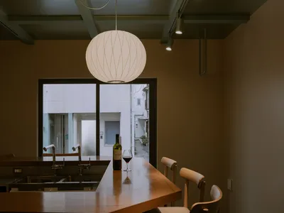 簡約廚房搭配木質座椅，玻璃吊燈懸掛其上