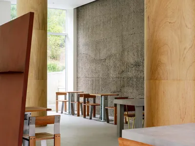 一間現代工業風餐廳，搭配木質餐桌以及混凝土地板與牆面。