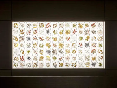 Modern restaurant interior featuring a glass cube with botanical illustrations