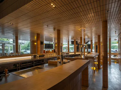 Industrial-style restaurant bar with wooden counter and metal seating