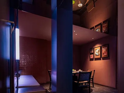 Modern minimalist restaurant interior with brick walls and warm lighting.