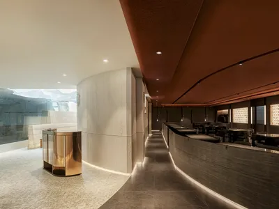 A modern restaurant interior featuring concrete walls and flooring.